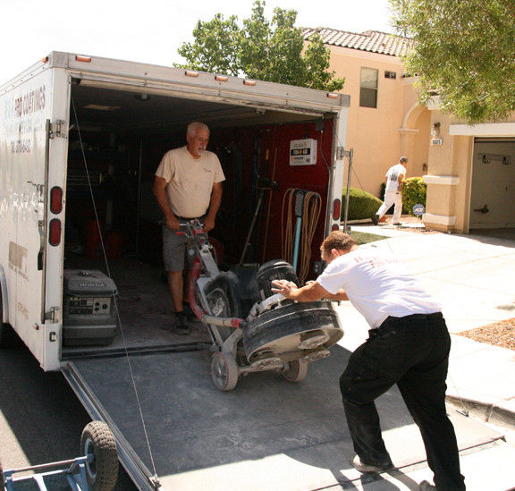 This image shows 2 men loading the polishing machine onto a truck.
