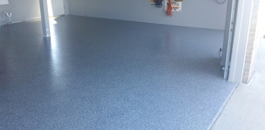 This image shows a garage floor with flake epoxy painted floor.