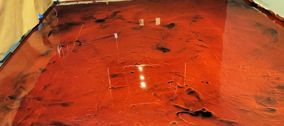This image shows a metallic epoxy floor that is very shiny. The floor's color is red.