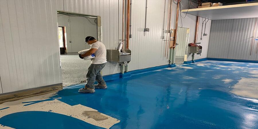 This image shows a man painting a floor.