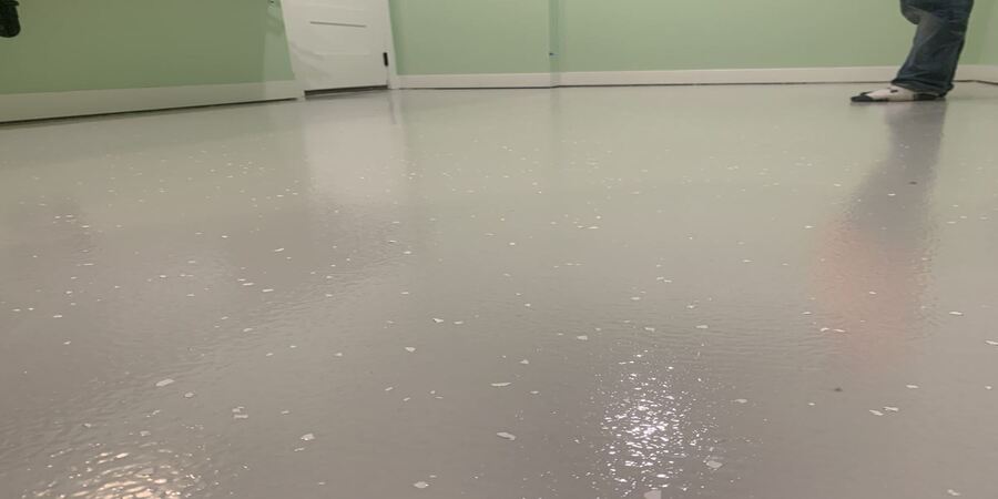 This image shows a man putting flakes on the floor.